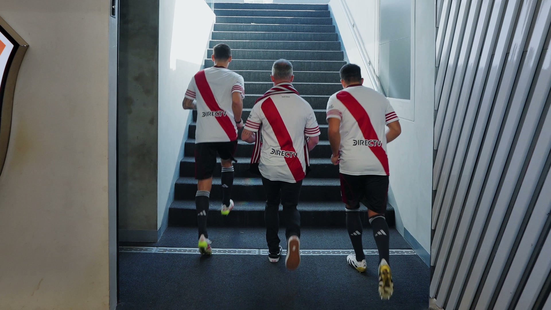 Tres jugadores suben la escalera hacia la cancha
